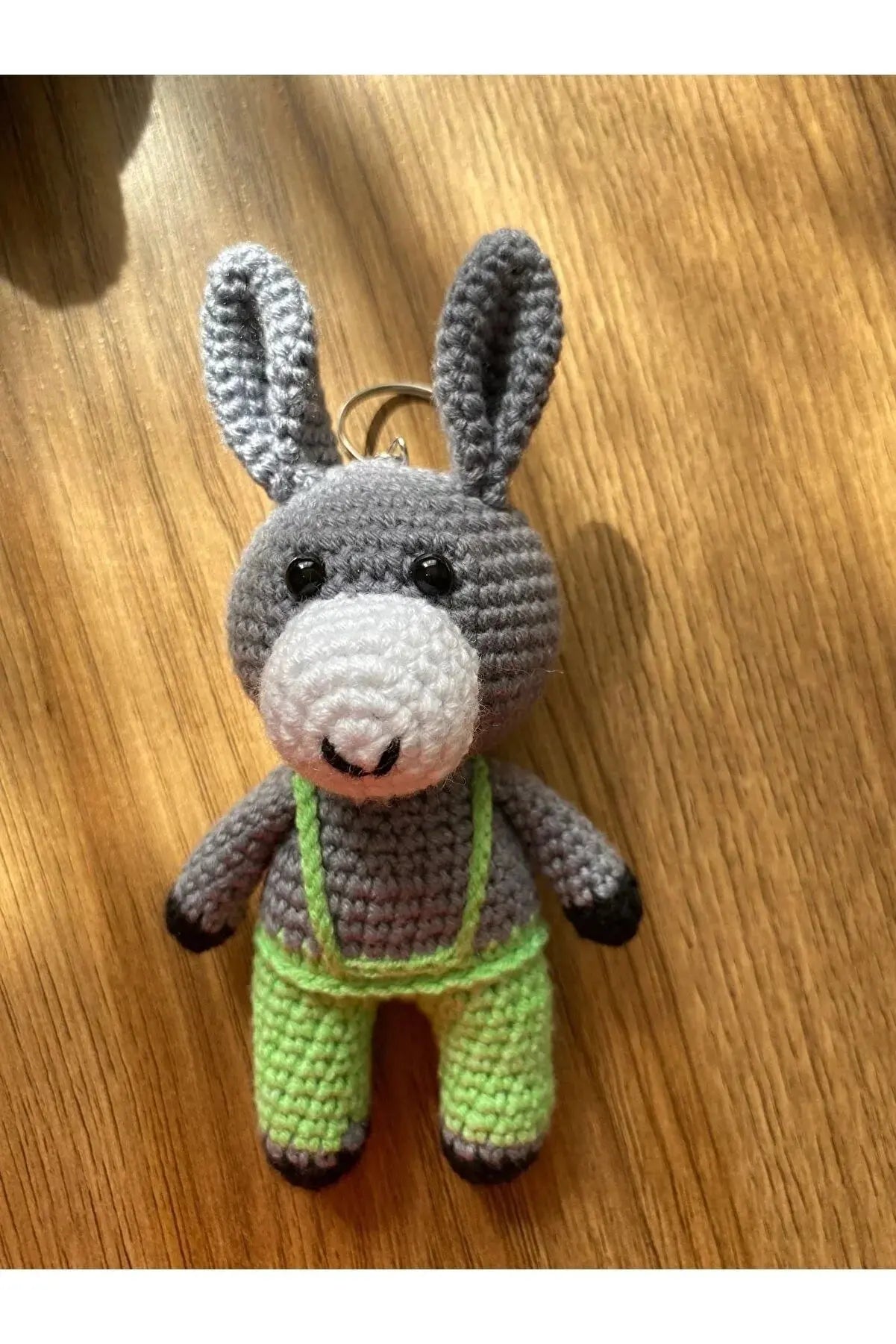 a crocheted bunny keychain on a wooden table