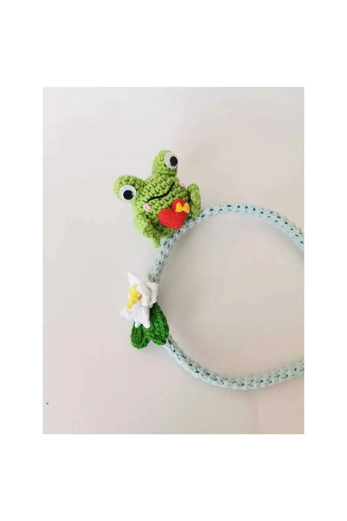 a crocheted frog with a red heart on it's head