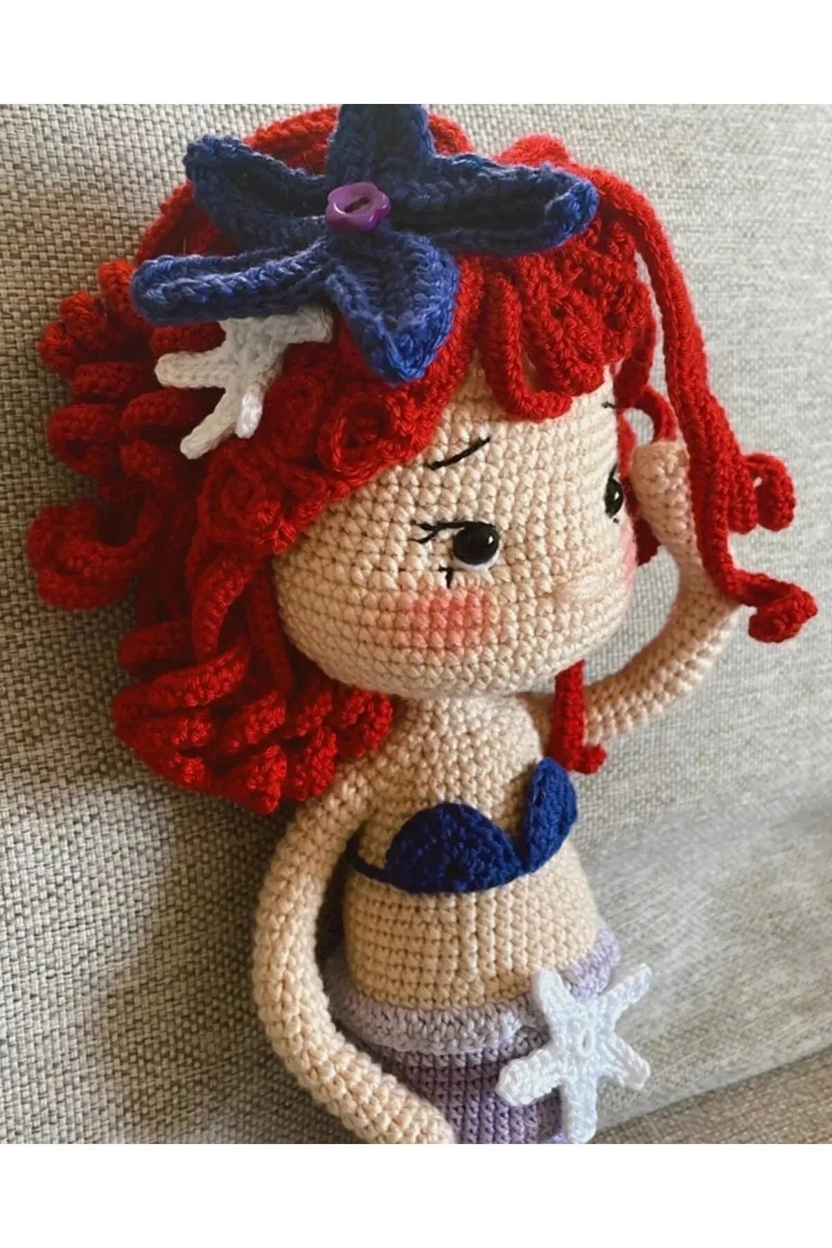 a crocheted mermaid doll sitting on a couch