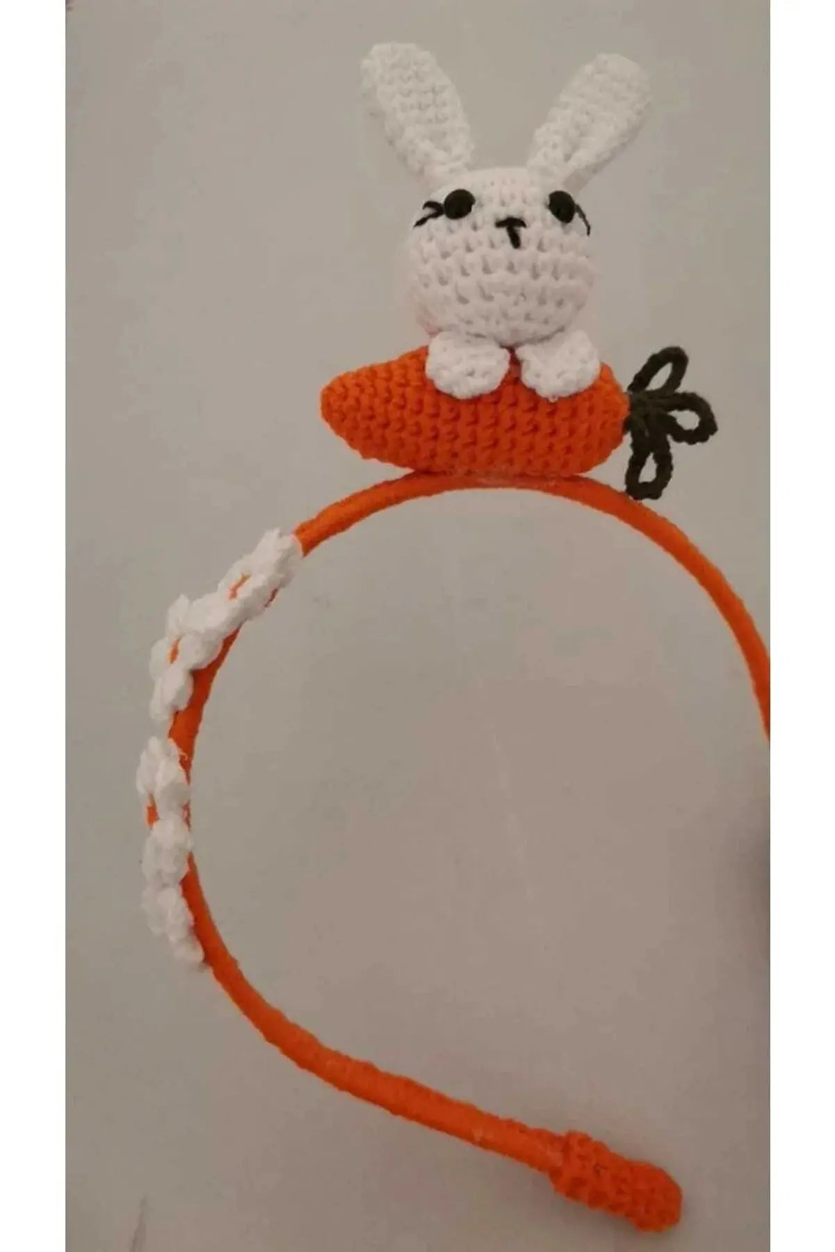 a crocheted carrot headband with a bunny on top of it