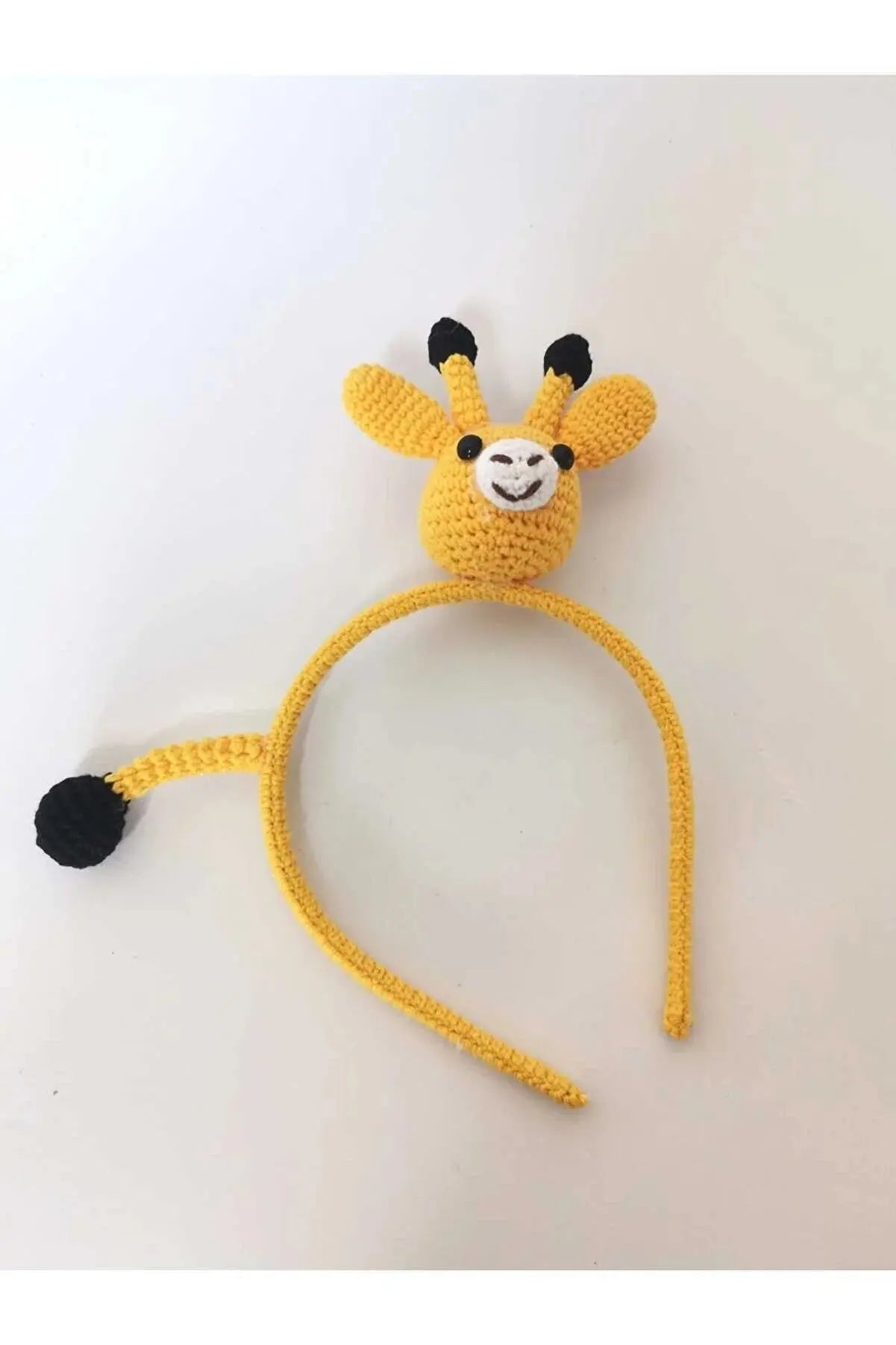 a crocheted giraffe headband with a black nose