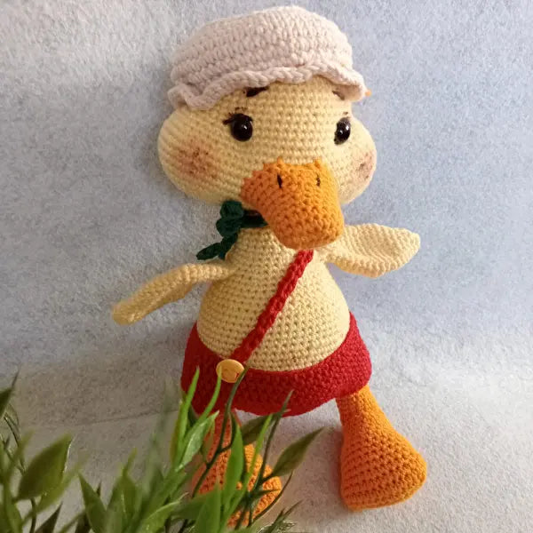 a crocheted duck with a hat and scarf