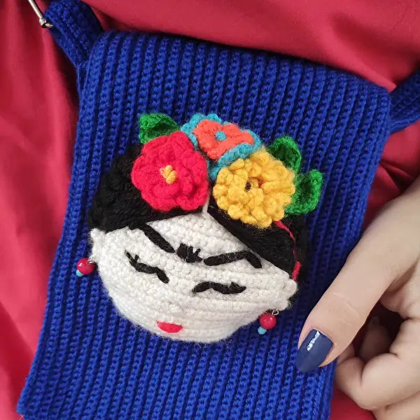 a woman's hand holding a crocheted purse with a crocheted