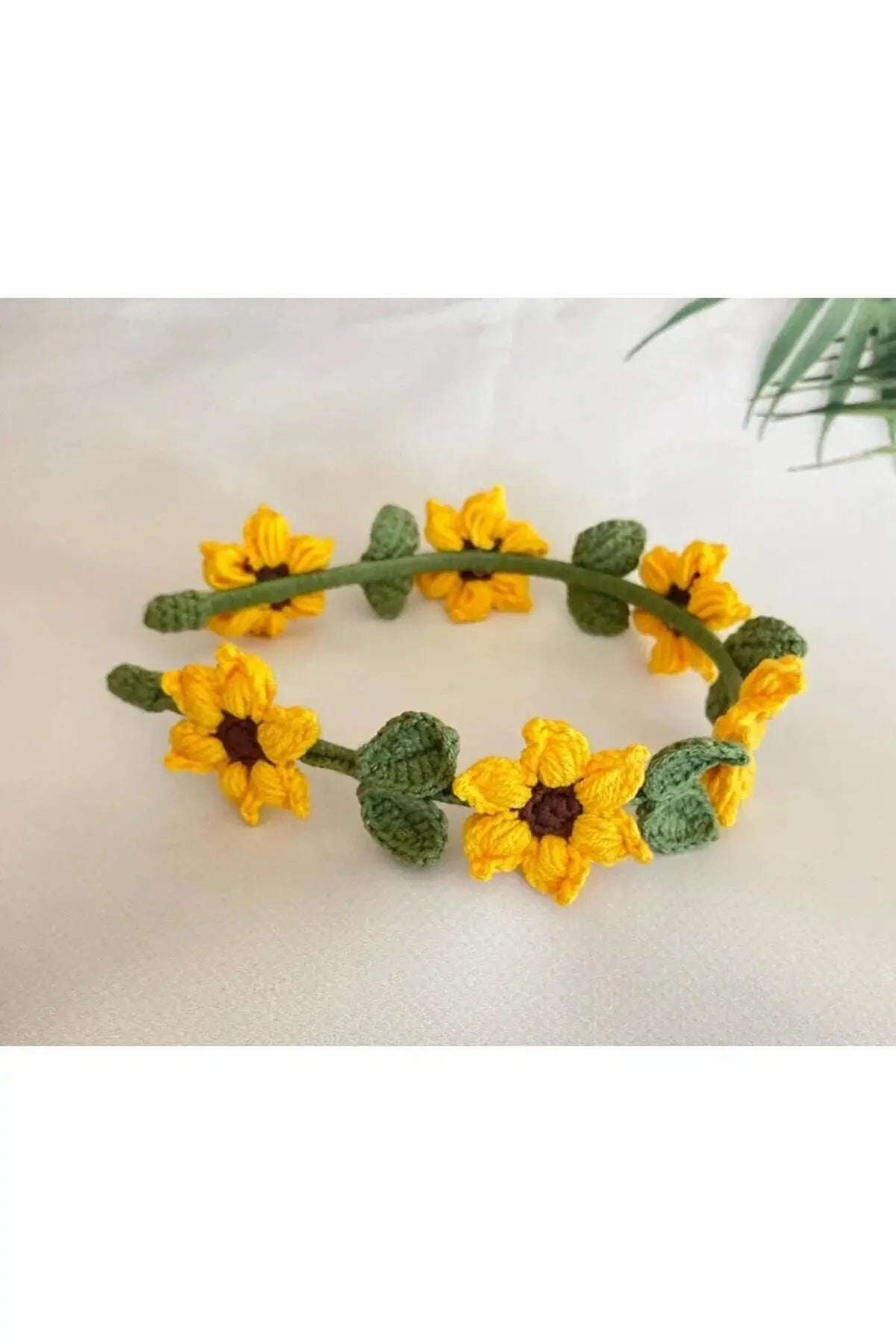 a crocheted sunflower headband with leaves