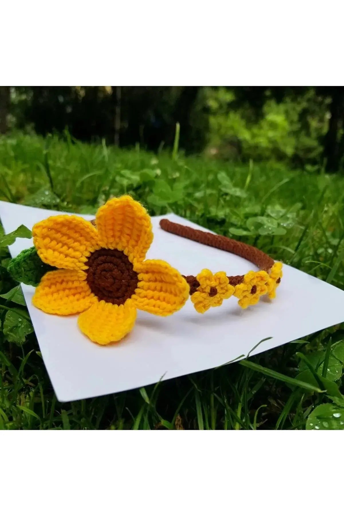 a crocheted flower headband on top of a piece of paper