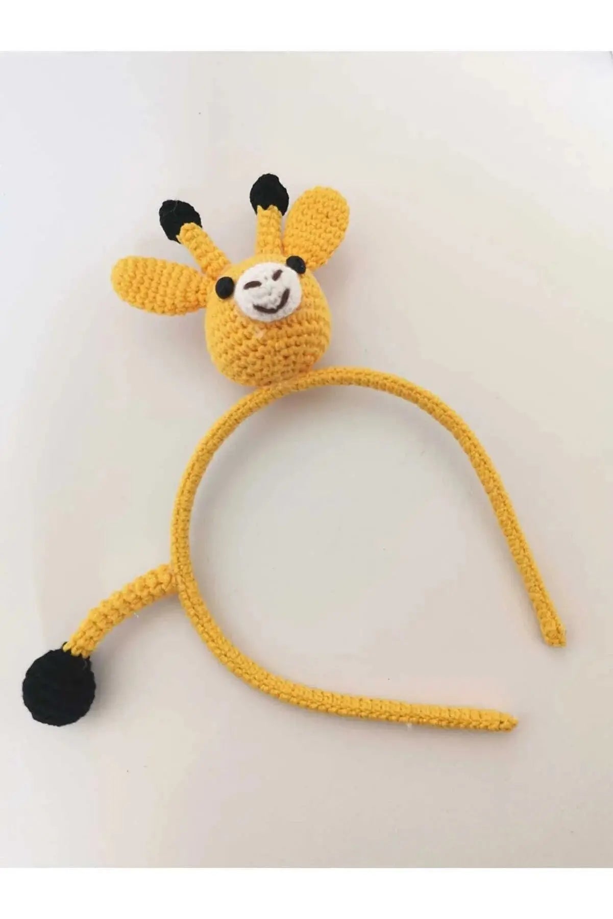 a crocheted giraffe headband with a black nose