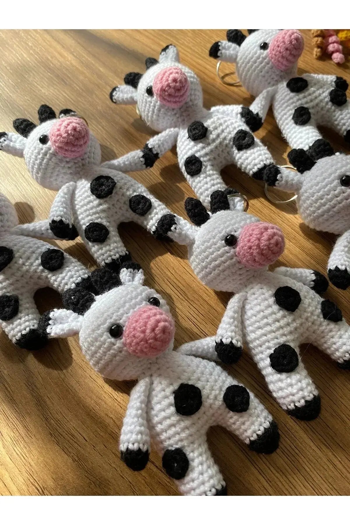 a group of knitted cows sitting on top of a wooden table