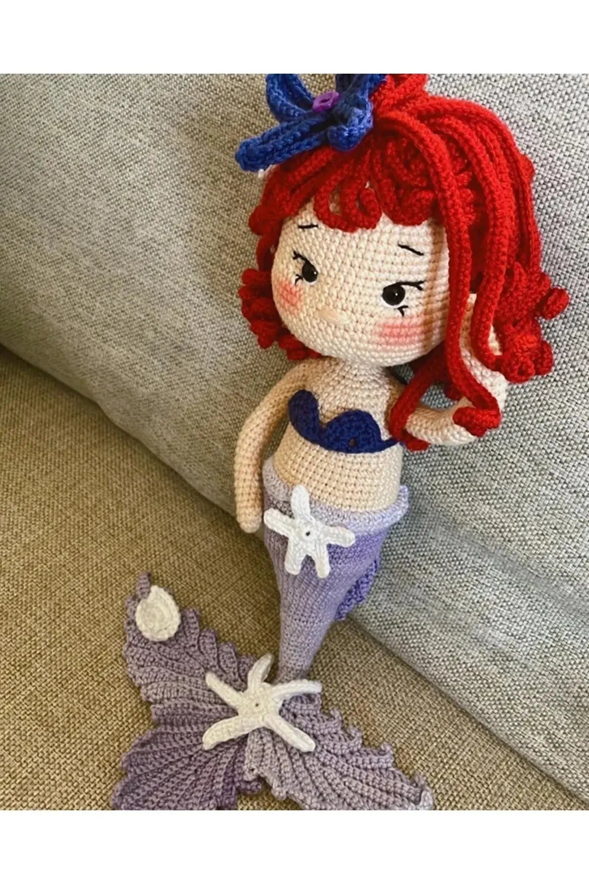 a knitted mermaid doll sitting on a couch