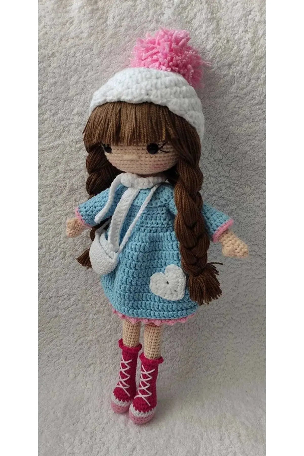 a crocheted doll with a hat and boots