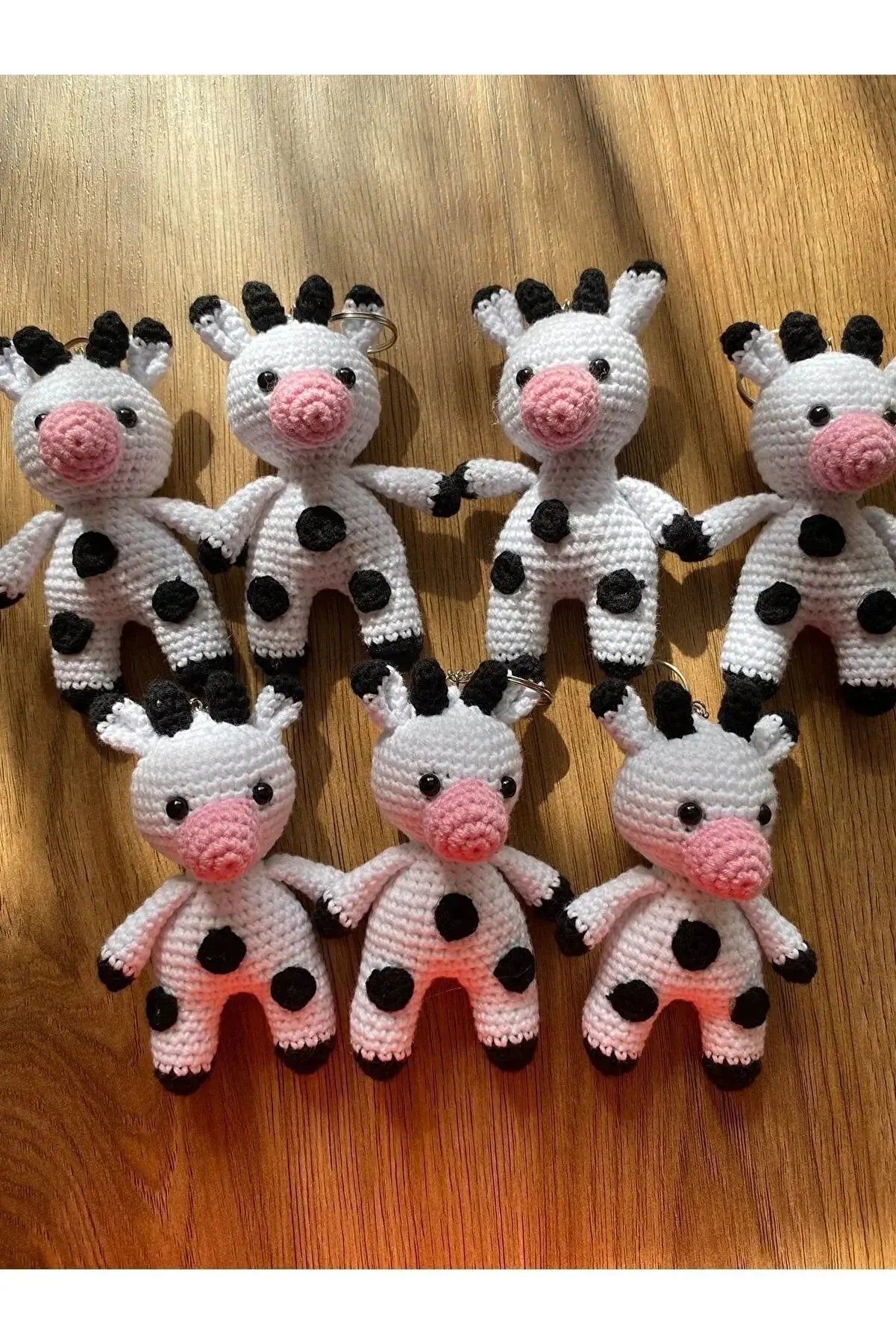 a group of knitted cows sitting on top of a wooden table