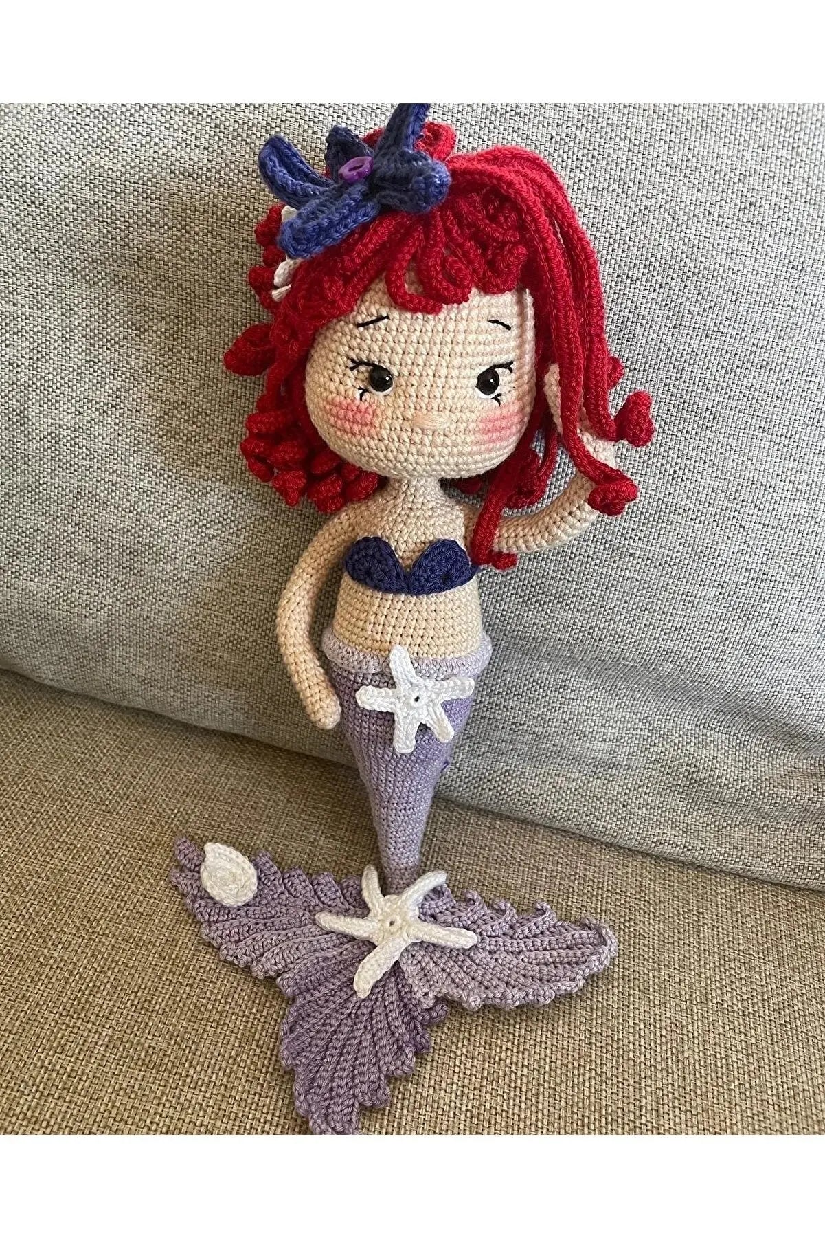 a crocheted mermaid doll sitting on a couch