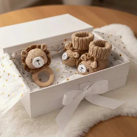 Handmade knitted lion baby rattle and booties in a white gift box with ribbon