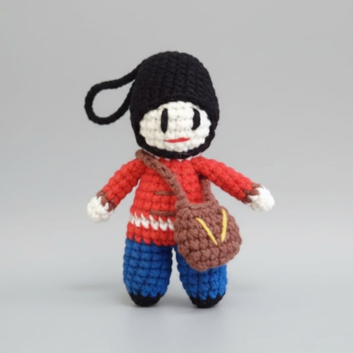 Crocheted mini dolls in red and blue uniforms with black heads, held in a hand
