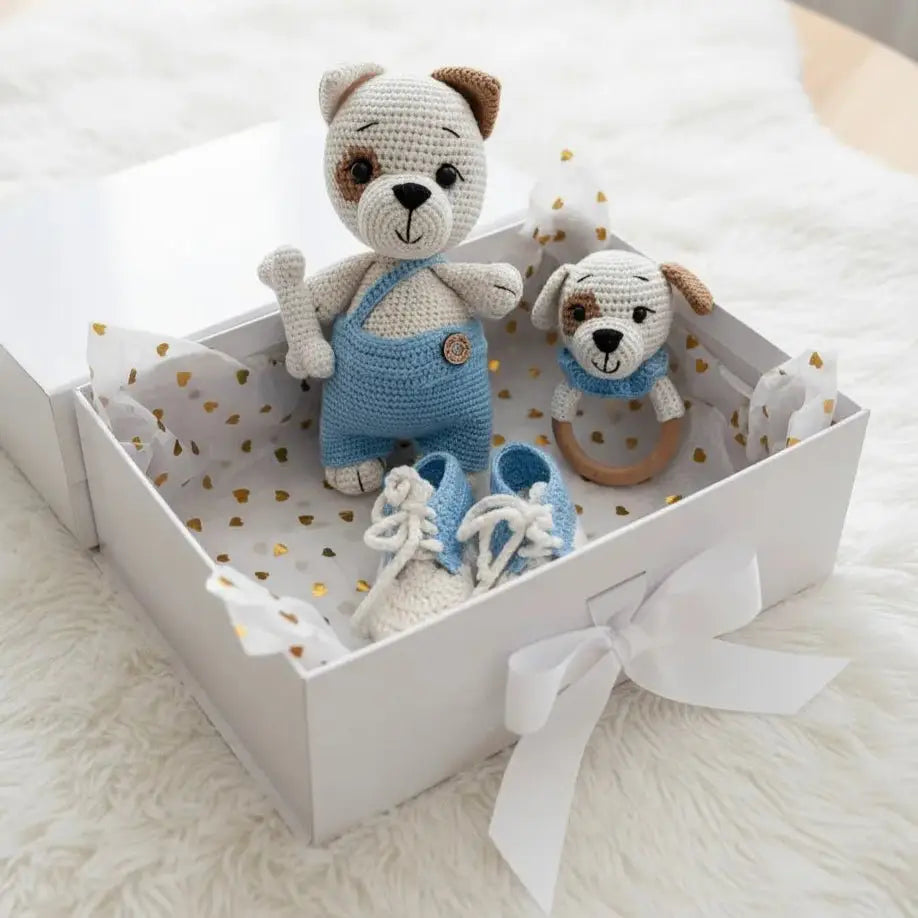 Crocheted bear and puppy toys with blue outfit and baby shoes in a gift box