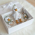 Crocheted duck dolls in white gift box with gold hearts, including teething ring and toy