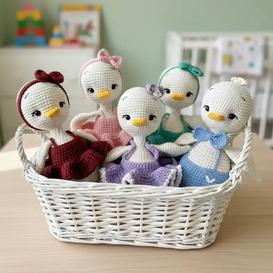 Five crocheted penguin dolls in colorful outfits nestled together in a white woven basket.