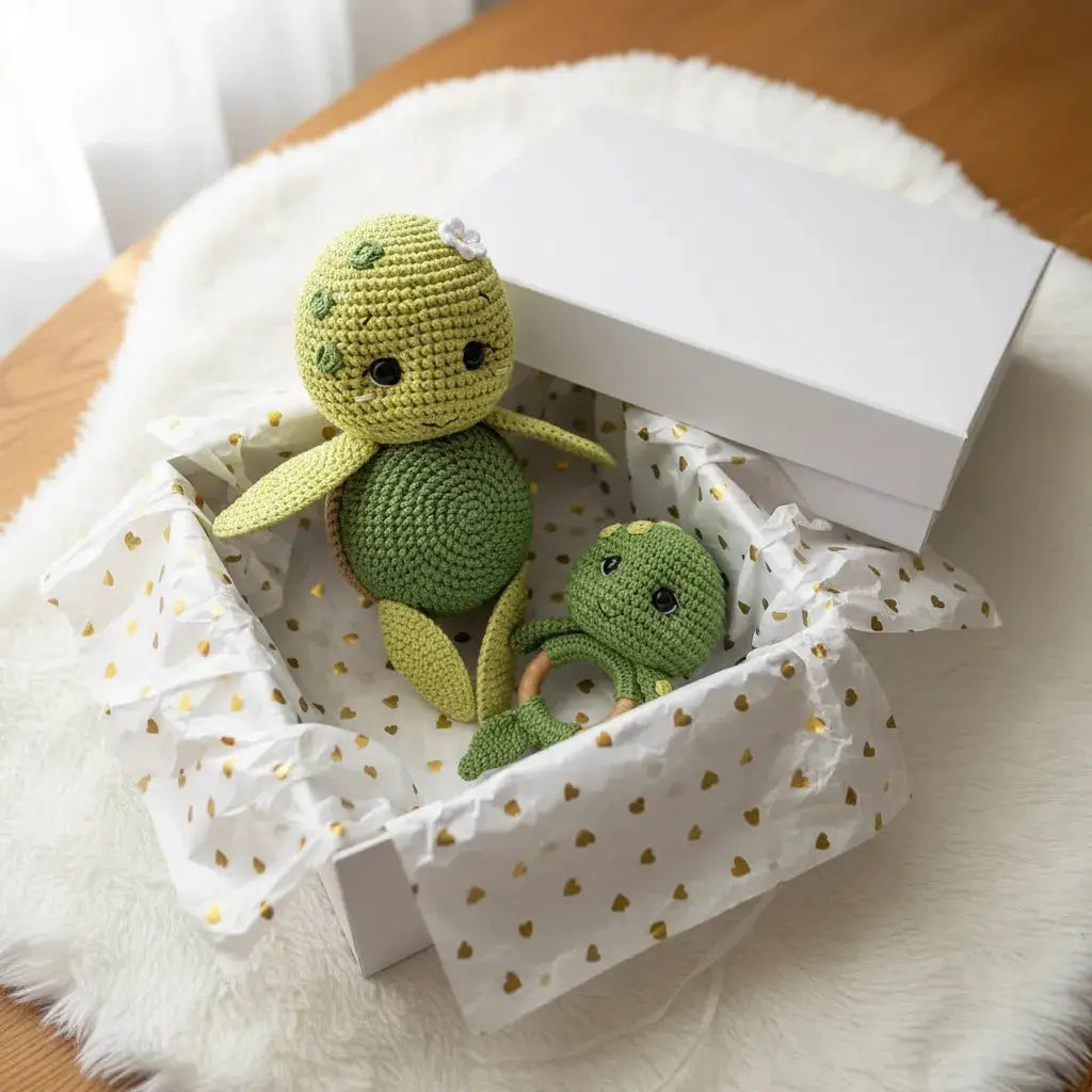 Crocheted green turtle toys nestled in heart-patterned gift box on fluffy white surface