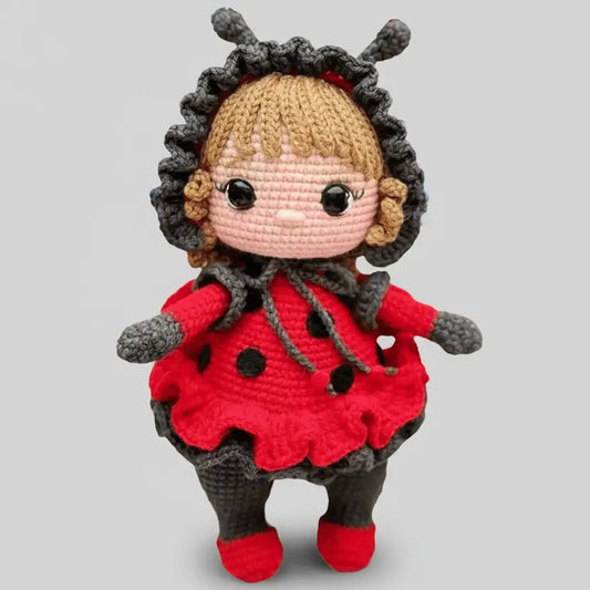 Crocheted ladybug doll with red dress, gray trim, and cute button eyes