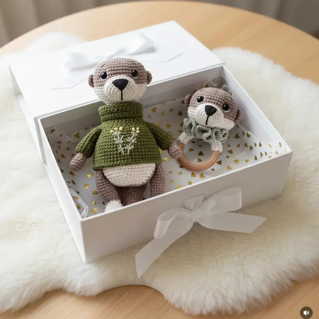 Crocheted teddy bear and baby rattle in a white gift box with gold hearts