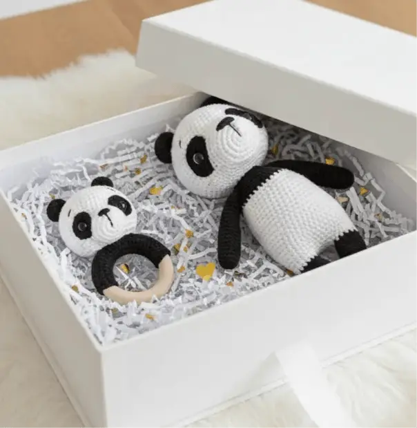 Crocheted panda stuffed animal and wooden teething ring in a white gift box
