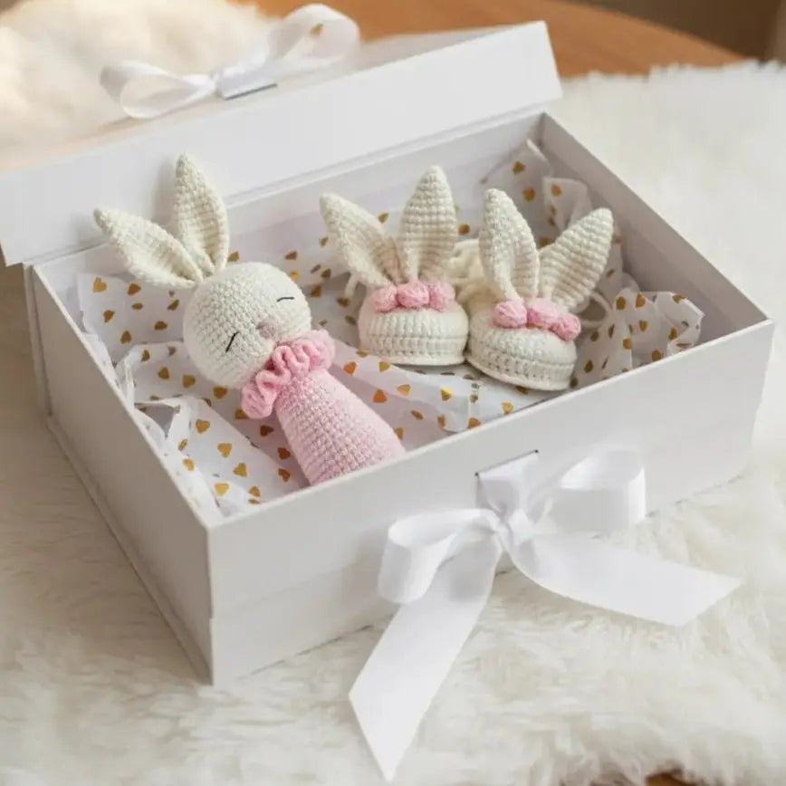 Handmade crocheted bunny dolls in a white gift box with gold heart pattern