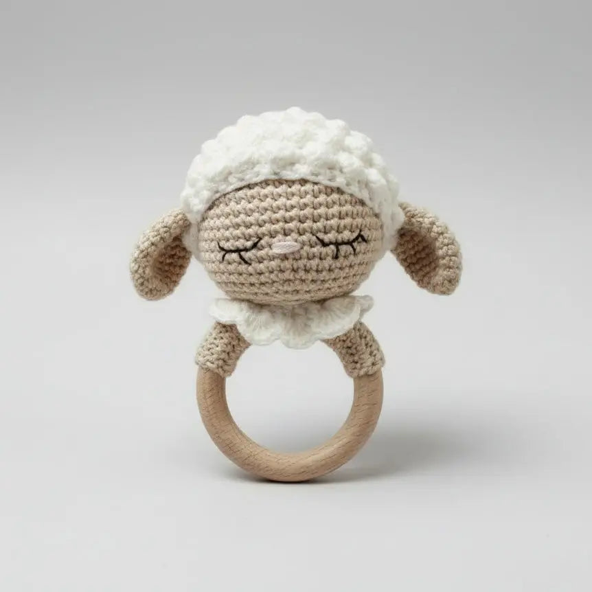 Crocheted sleepy lamb baby rattle with wooden ring, soft neutral colors