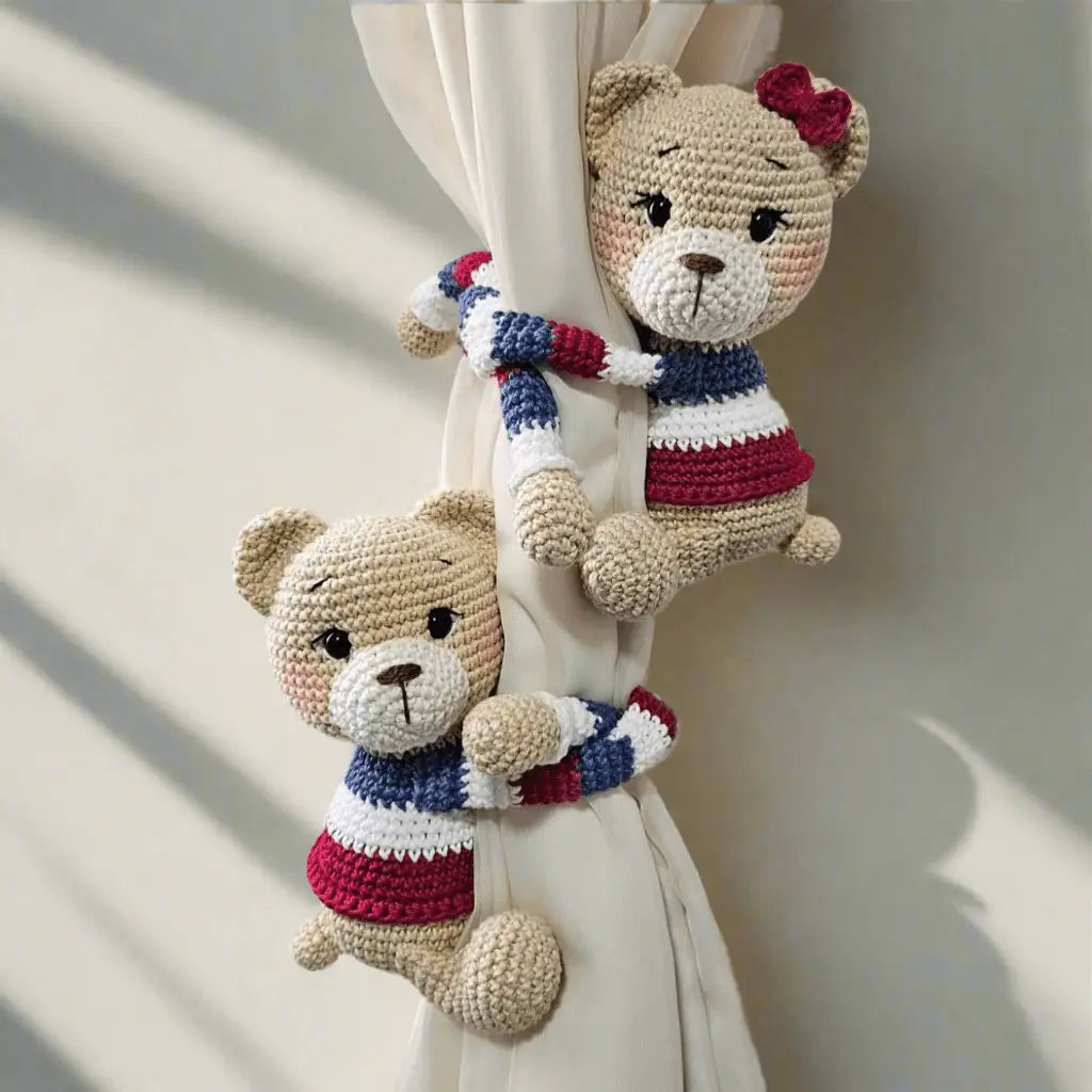 Two crocheted teddy bears in red, white, and blue, holding onto a curtain.