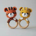 Two crocheted tiger baby rattles, orange and yellow, with wooden rings