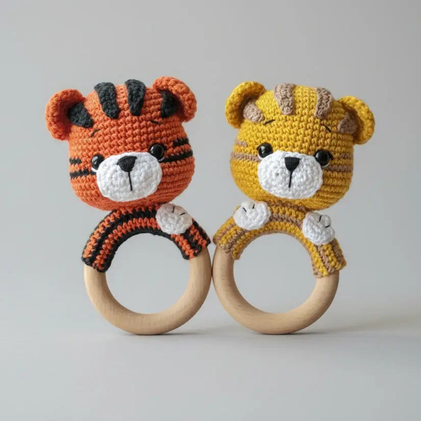 Two crocheted tiger baby rattles, orange and yellow, with wooden rings