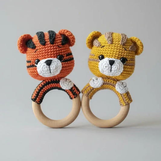 Two crocheted tiger baby rattles, orange and yellow, with wooden rings