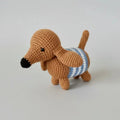 Crocheted brown dachshund with blue and white striped sweater on gray background