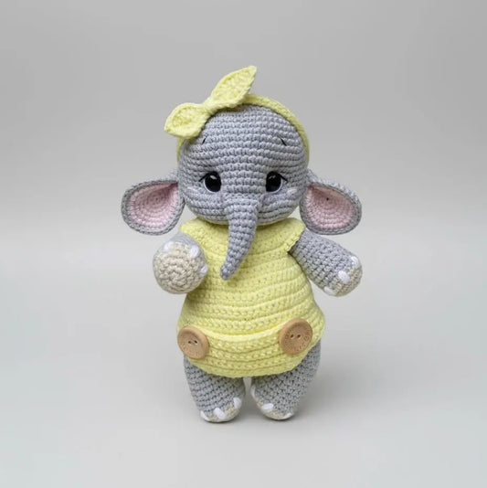 Crocheted elephant in yellow dress with bow, soft grey and pink yarn, cute button details