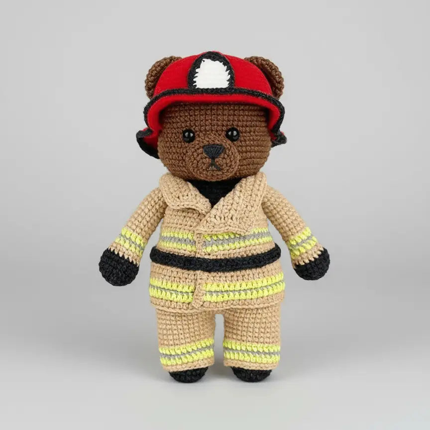 Crocheted teddy bear wearing firefighter uniform and red helmet