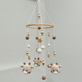 Crocheted baby mobile with deer, wooden beads, white spheres, and a golden star