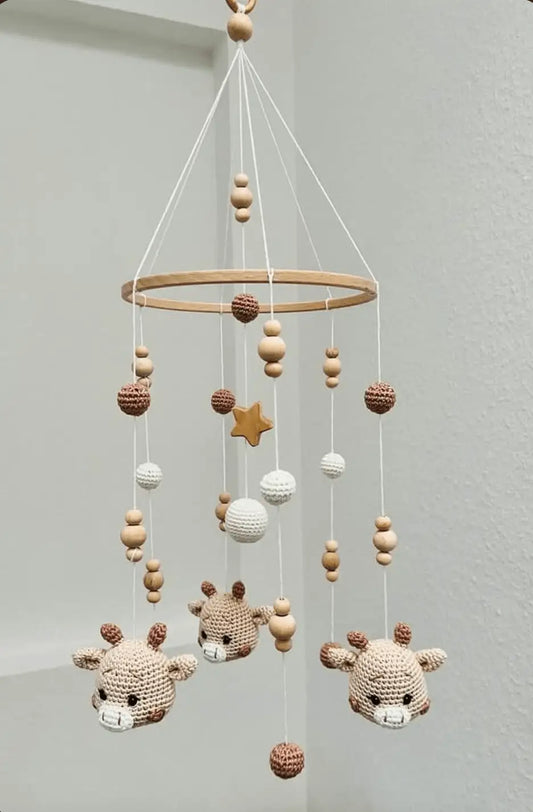 Crocheted baby mobile with deer, wooden beads, white spheres, and a golden star