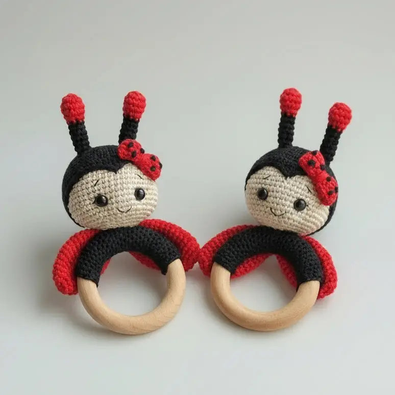 Two crocheted ladybug-themed baby teething rings with wooden circles and smiling faces