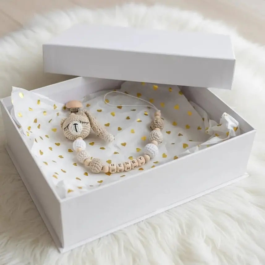Crocheted bunny and personalized name beads in a white gift box with gold heart pattern
