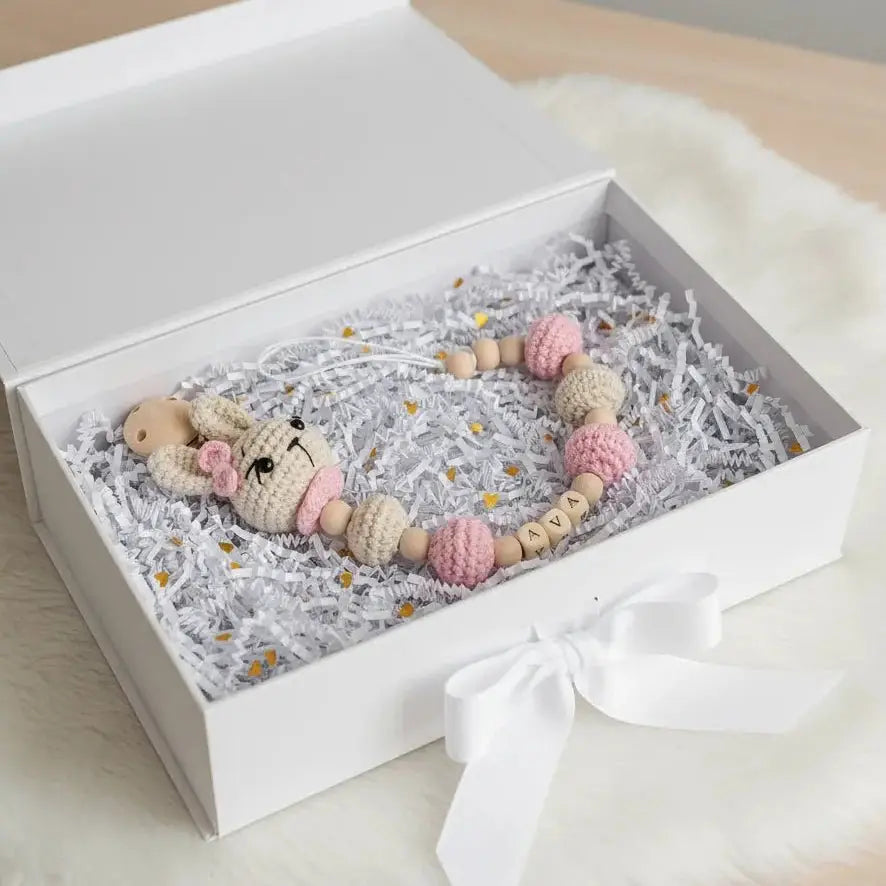 Handmade crochet bunny and wooden beads in a white gift box with ribbon and shredded paper