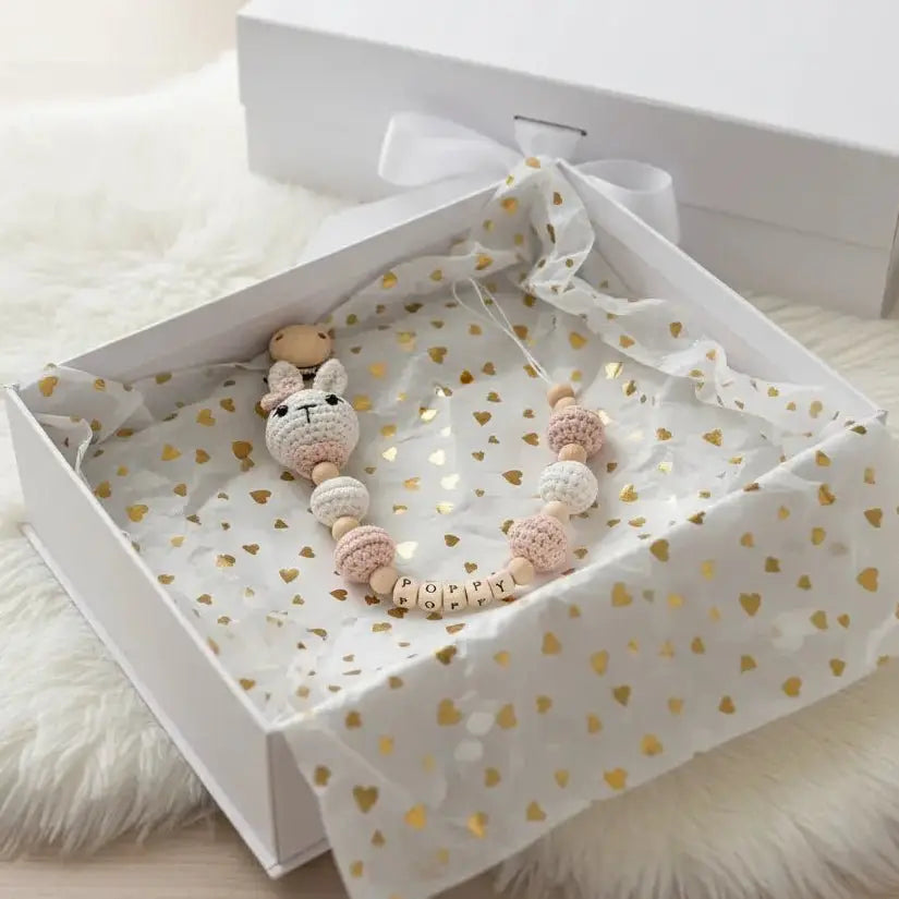 Personalized baby teething necklace with crocheted bunny in heart-patterned gift box