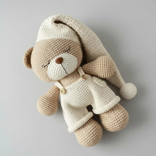 Crocheted teddy bear in cream and beige, wearing a white jacket, sleeping peacefully