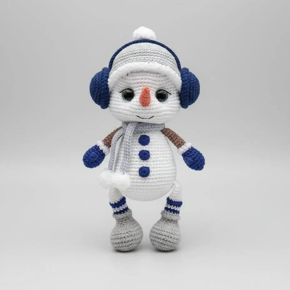 Crocheted snowman with blue earmuffs, scarf, and buttons, standing on a white background