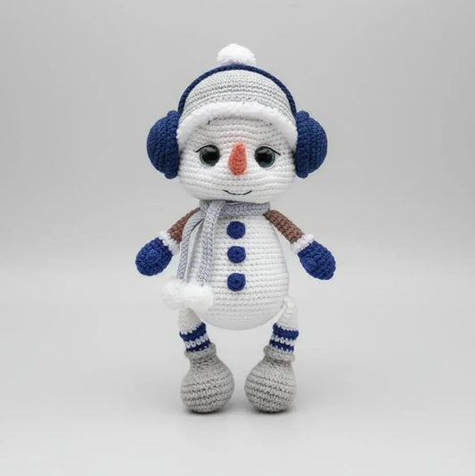 Crocheted snowman with blue earmuffs, scarf, and buttons, standing on a white background