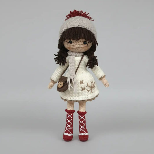 Crocheted doll in white winter outfit with red boots and pom-pom hat