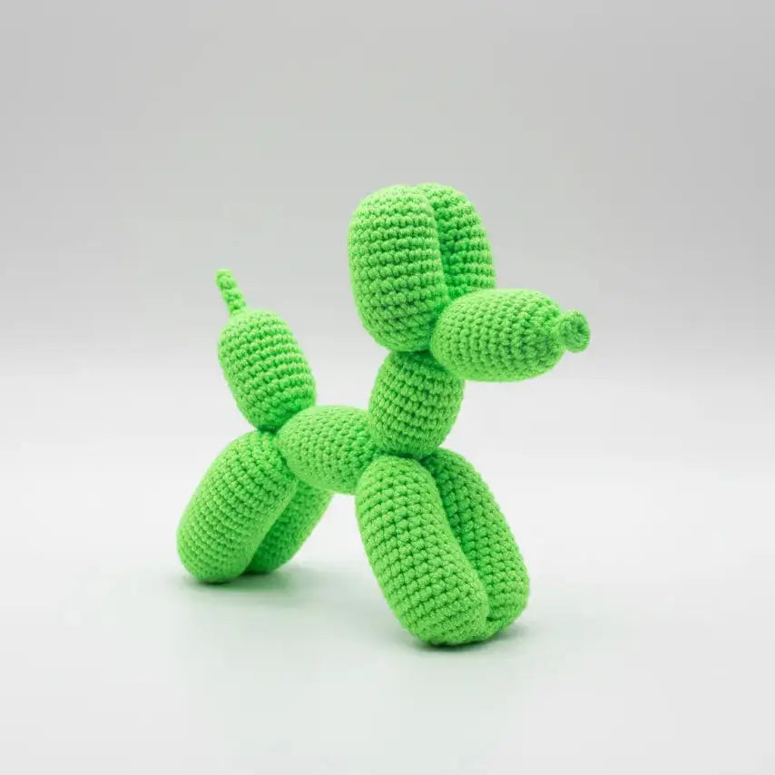Bright green crocheted balloon dog sculpture on a white background