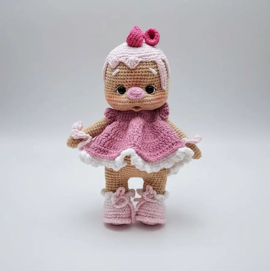 Crocheted amigurumi doll in pink dress with cupcake-inspired hat and booties