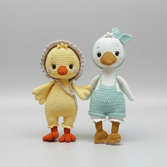 Two crocheted bird dolls, one yellow and one mint green, standing side by side on gray background