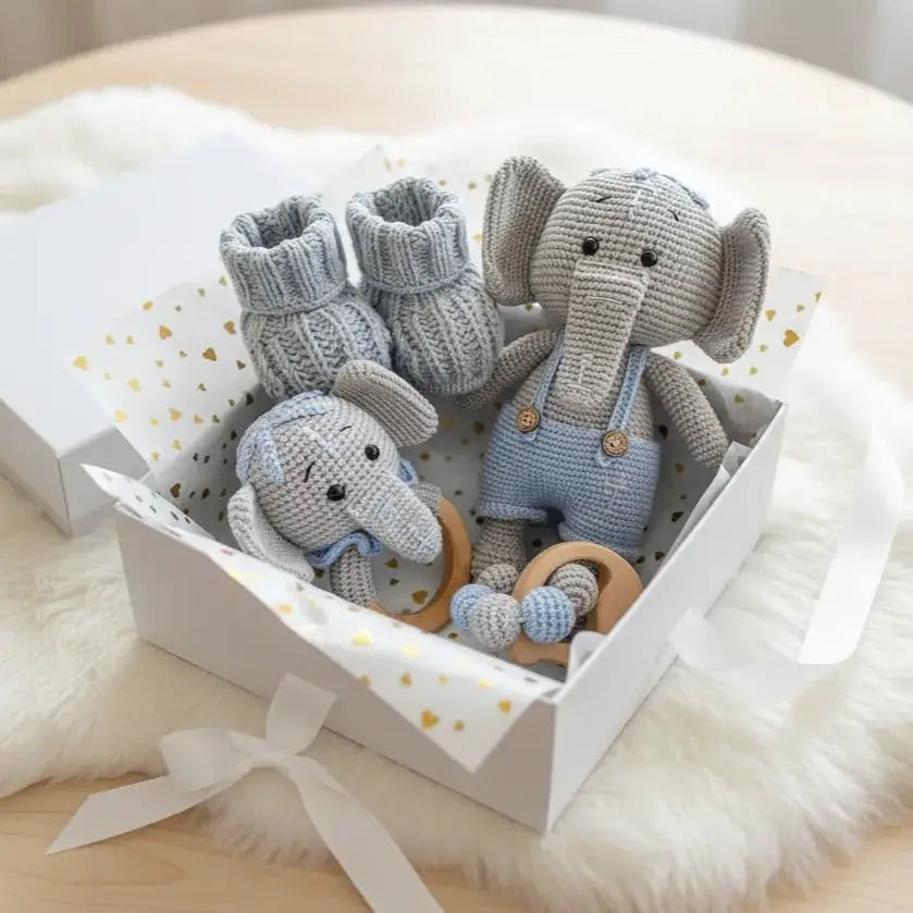 Knitted elephant toys and booties in a white gift box with gold hearts