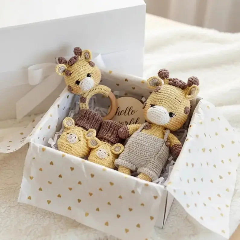 Crocheted giraffe toys in a heart-patterned gift box with "hello world" tag