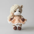 Crocheted stuffed animal horse wearing peach dress with ruffled trim and fluffy hair