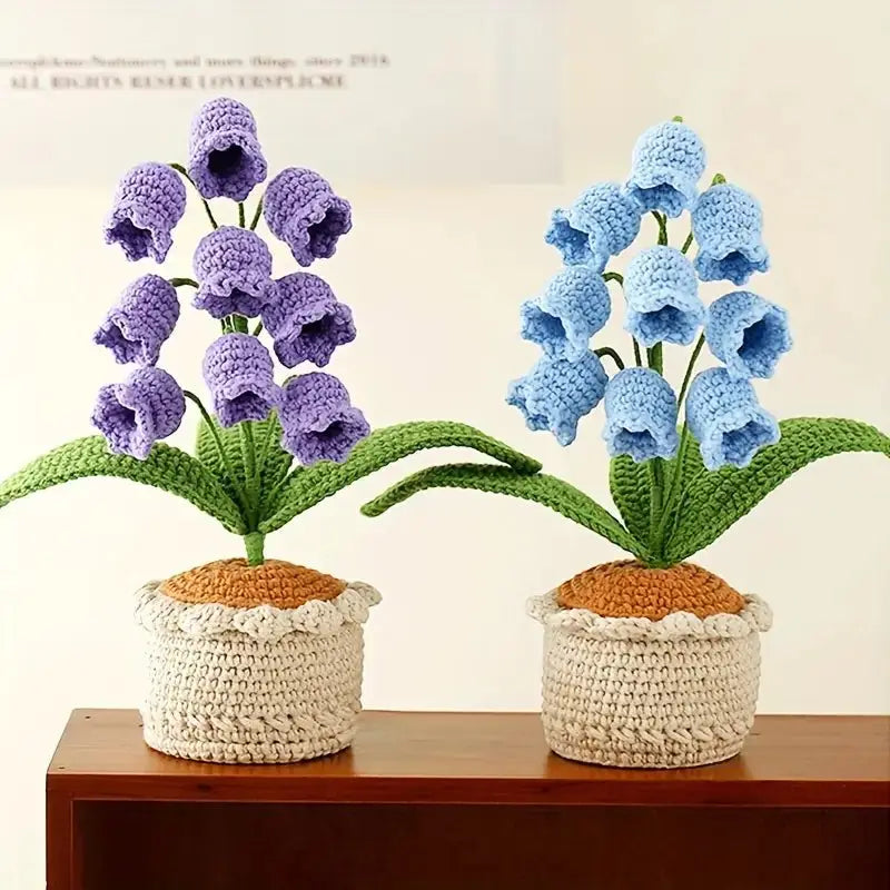 Crocheted purple and blue bell-shaped flowers in textured ceramic pots on wooden shelf